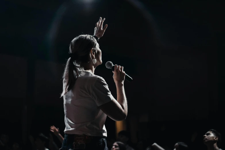 a female standing with a microphone in her hands