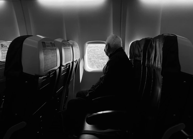 a man is looking out the window at some planes