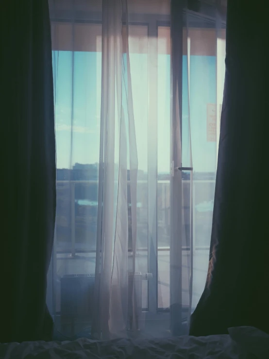 curtains hang in the sunlight behind the sheered window