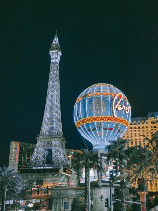 the eiffel tower and some palm trees at night