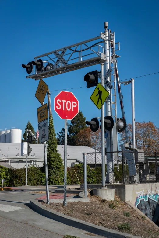 a street sign next to a traffic signal and railroad crossing