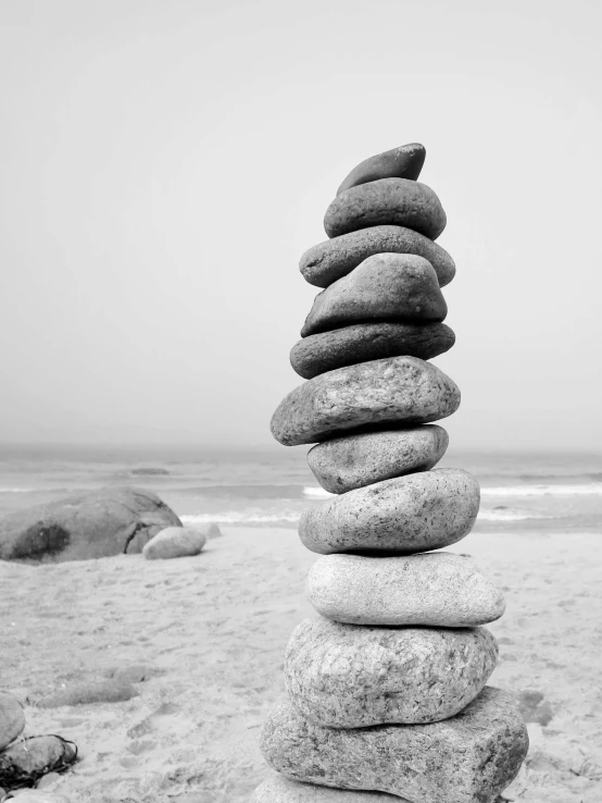 stacked rocks are balanced on the beach shore