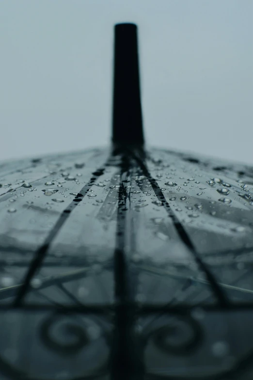 the top part of a umbrella with several drops of rain