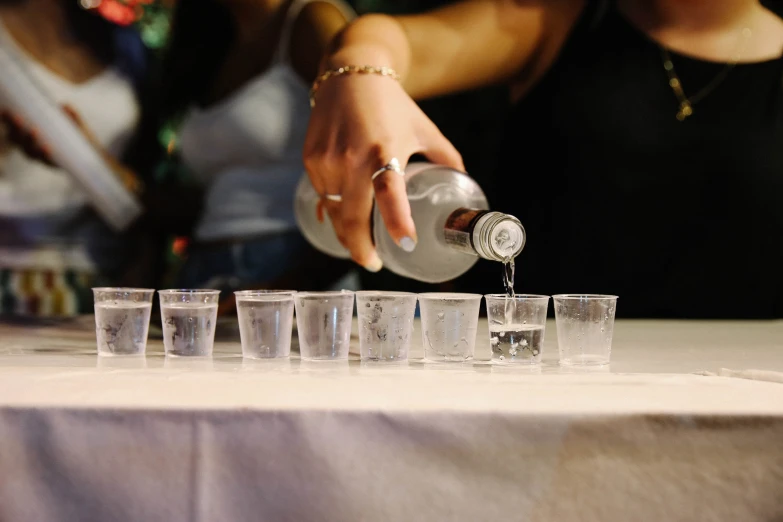 a woman is pouring soing into glasses on a table