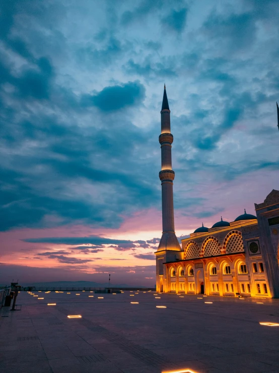 the mosque in the evening with its lights on