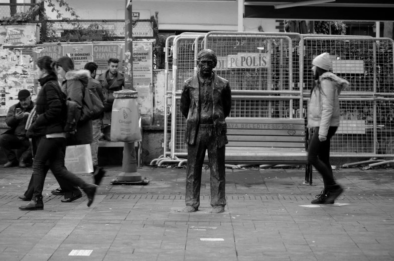 a man with a hat on walking near a group of people