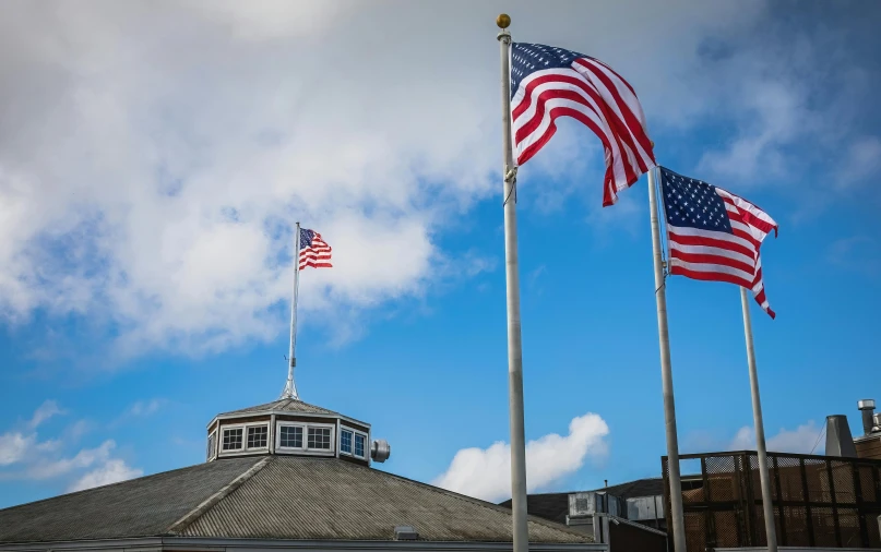 three american flags sitting in front of an ornate domed building