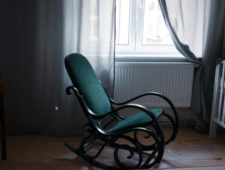 a rocking chair near a window with curtains