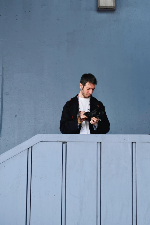 a man looking at his cell phone on the ledge