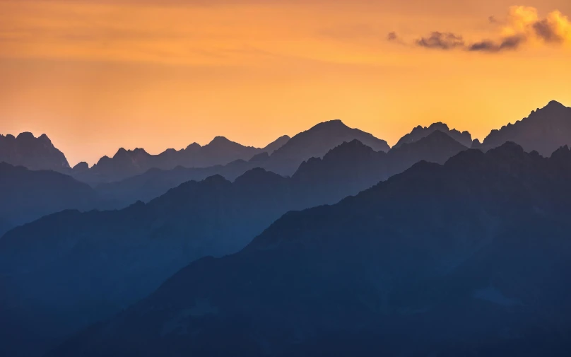 the sun rising over the mountains with a plane in it's shadow