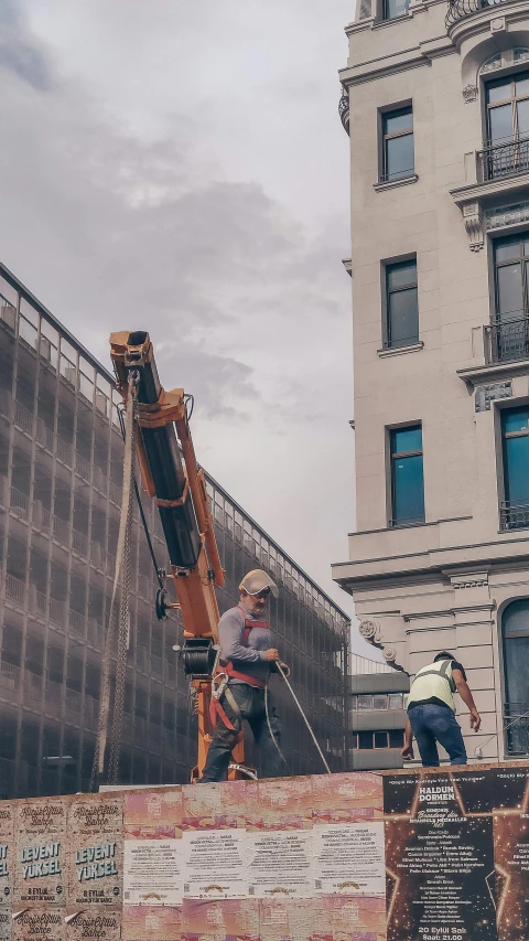 two construction workers standing on top of a building