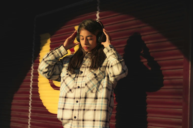 a girl listening to headphones standing on the street