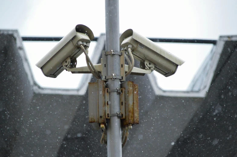 a couple of cameras mounted on the side of a building