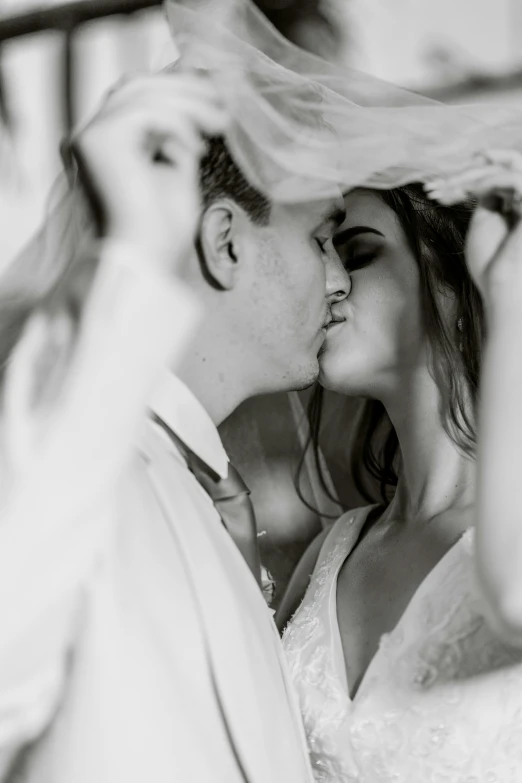 the bride and groom are kissing