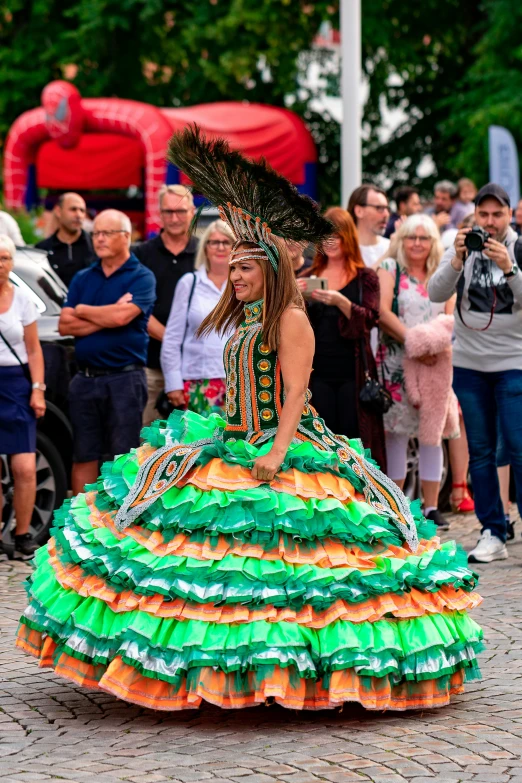 a woman dancing with her colorful dress in the street