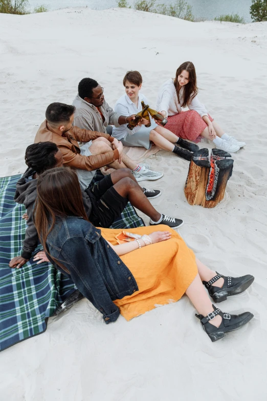 several people sitting in the sand together on the beach