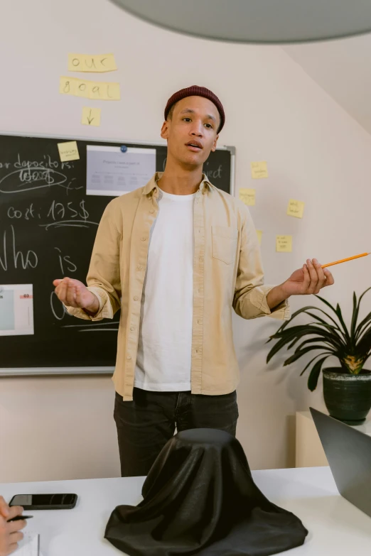 a man standing in front of a blackboard giving a presentation