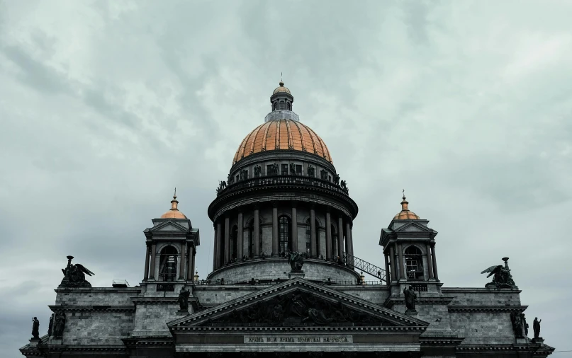 a building with two towers on top against a cloudy sky