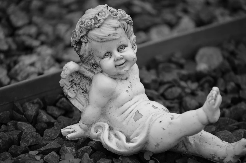 a black and white po of a statue sitting on gravel