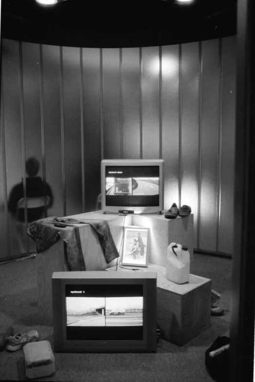 a room with a man in the background and various electronics on the table