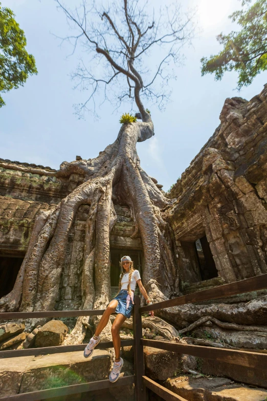 a person posing in front of an ancient tree