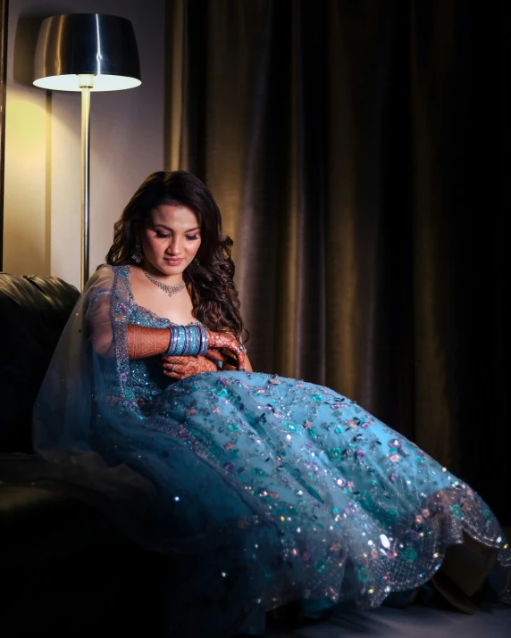 a beautiful young woman sitting in a blue dress