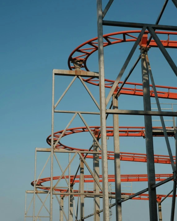 a roller coaster against a blue sky in the day