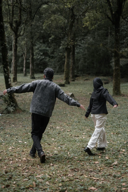 two people walking across the grass holding hands