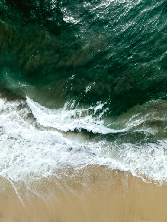 aerial view of waves and sand on the beach