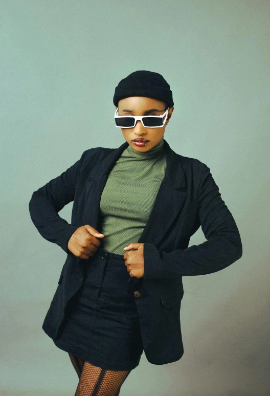 a woman wearing a suit and sunglasses poses for a picture