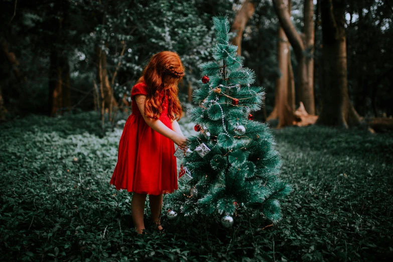 a girl is holding up the christmas tree