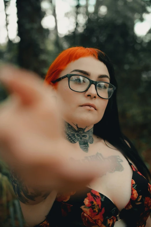 a woman is making an ok sign near some trees