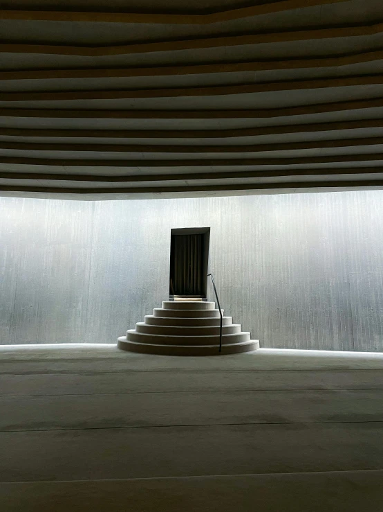 an empty room with a stair leading up to a door