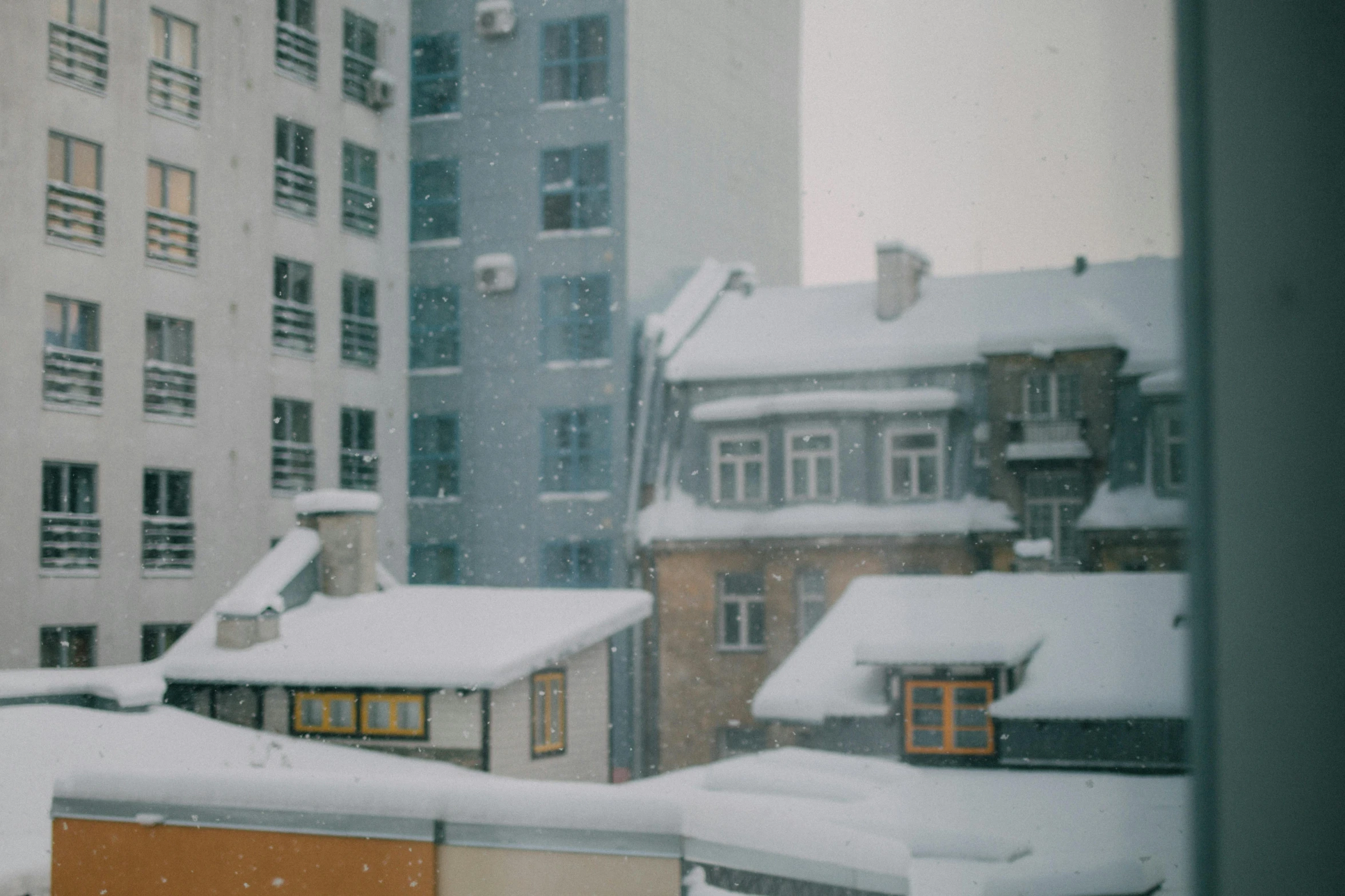 the view from a snowy roof to buildings and windows