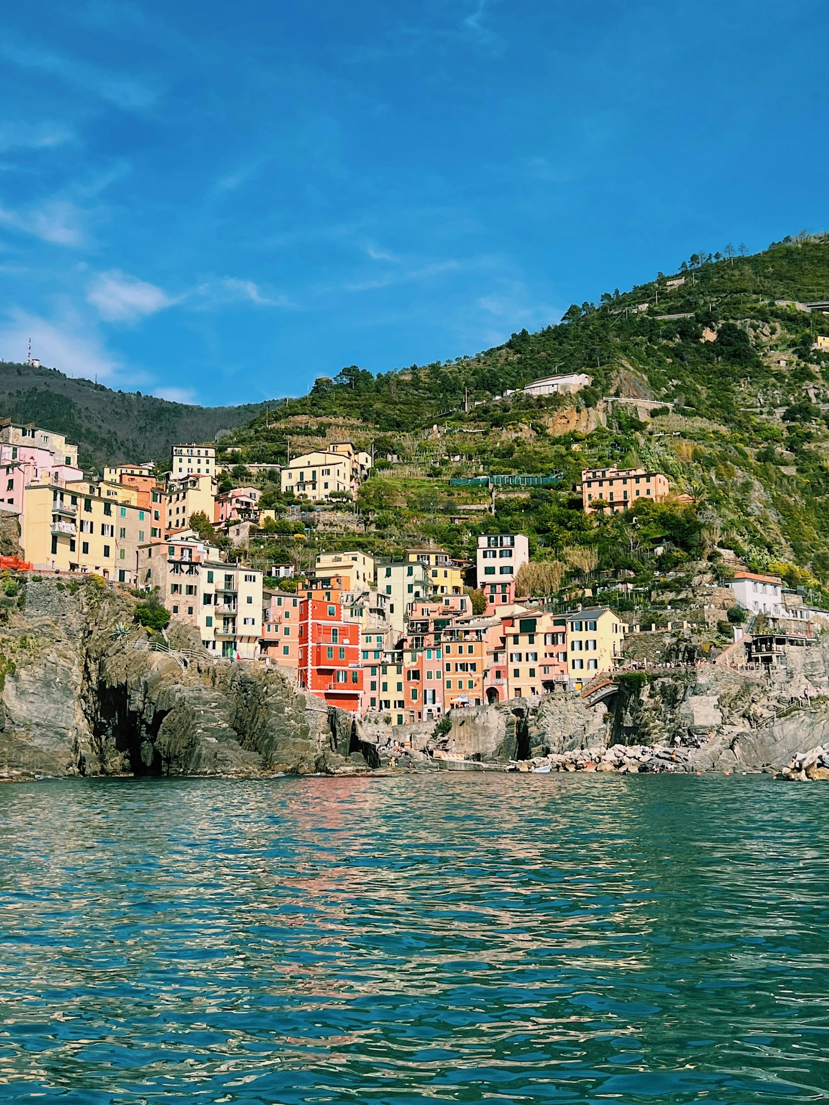 some buildings sitting on top of a hillside next to the water