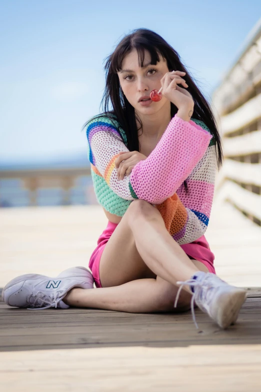 a woman is sitting on the ground while posing for a po