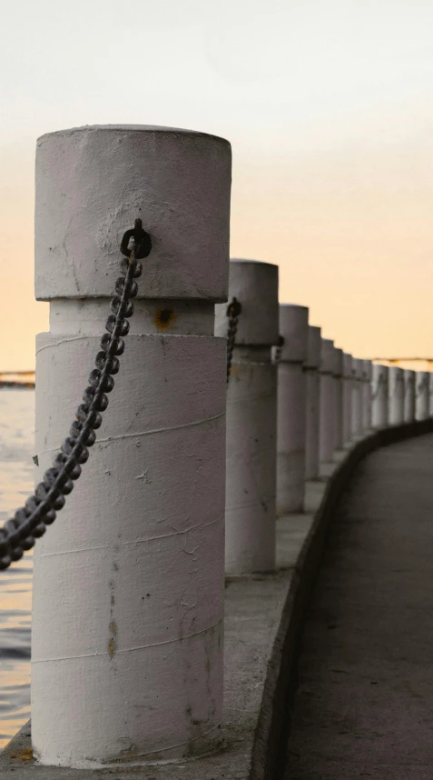 a long fence on a waterfront next to the ocean