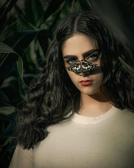 a girl with long hair wearing a black nosepiece with a erfly print on her forehead