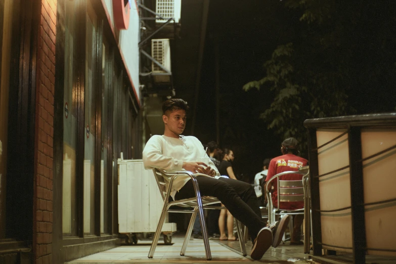 a man sitting on a chair on the outside