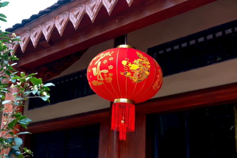 a red chinese lantern hanging on the outside of a building