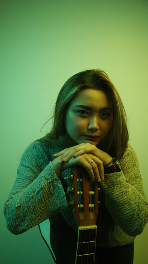 a woman sitting with her fingers on a guitar