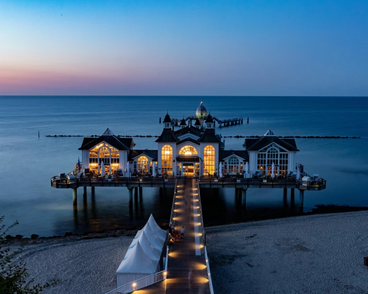 a pier and house with lit up lights on it at night