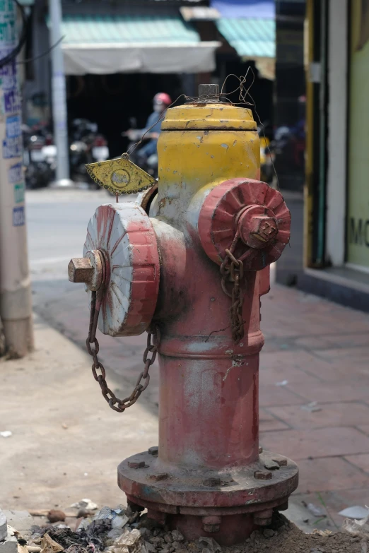 an old fire hydrant has some metal chains on it