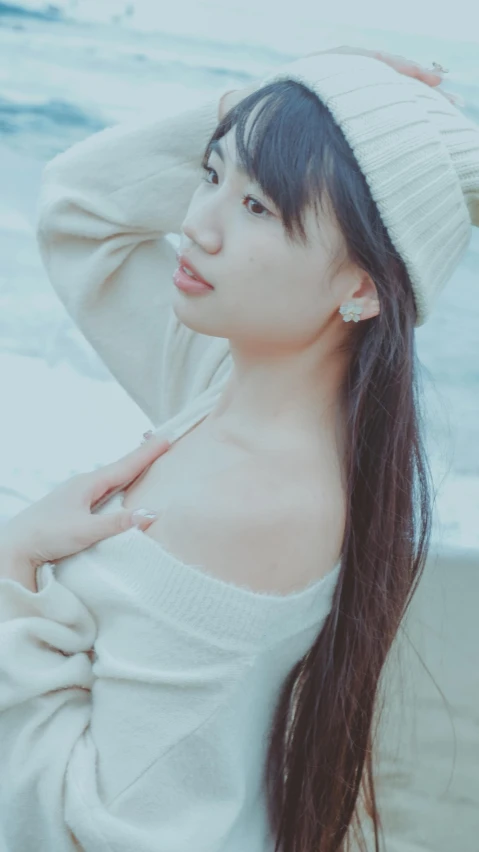 a woman with a white hat posing on the beach