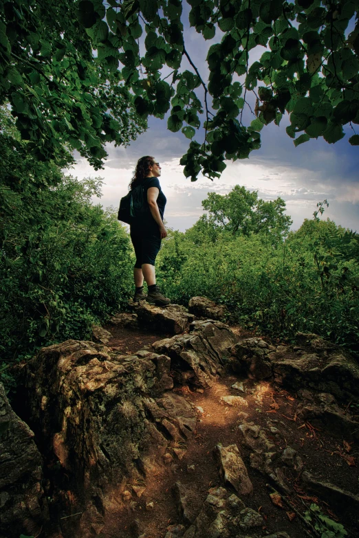 a young woman is on a rock with her backpack