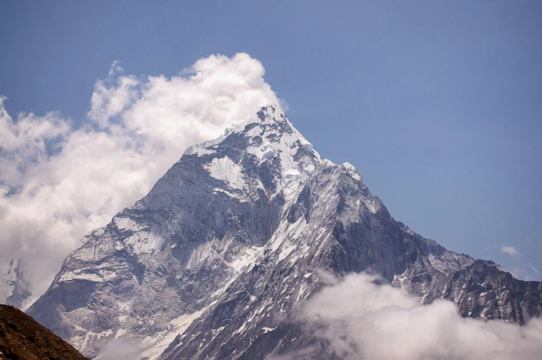 a view of a mountain with clouds and blue sky