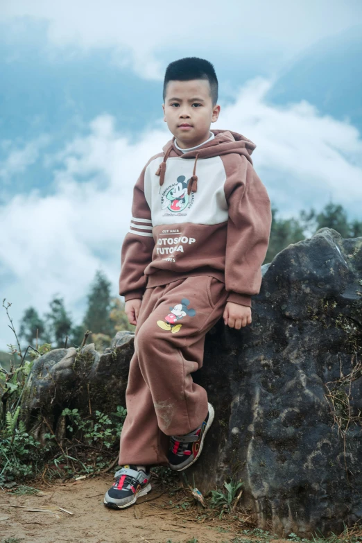 a young child is sitting on the rocks