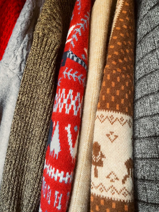 a variety of sweaters hanging on racks