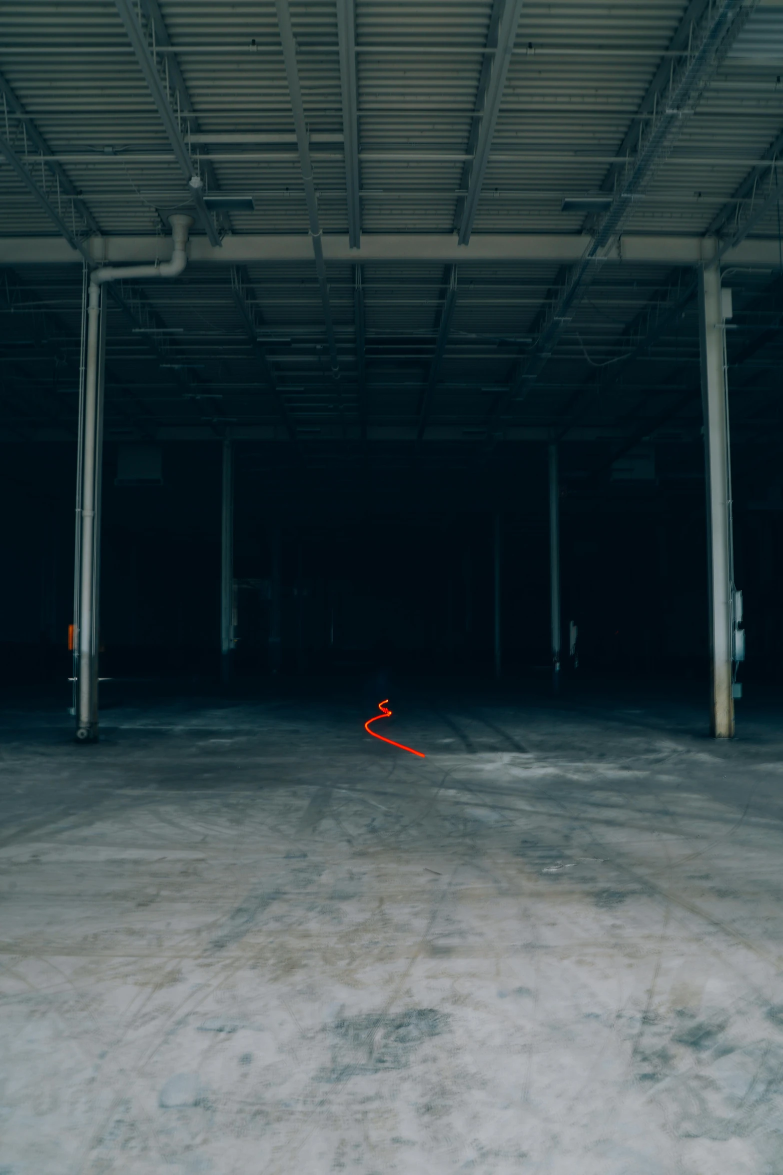 a fire hydrant inside of a very dark parking garage