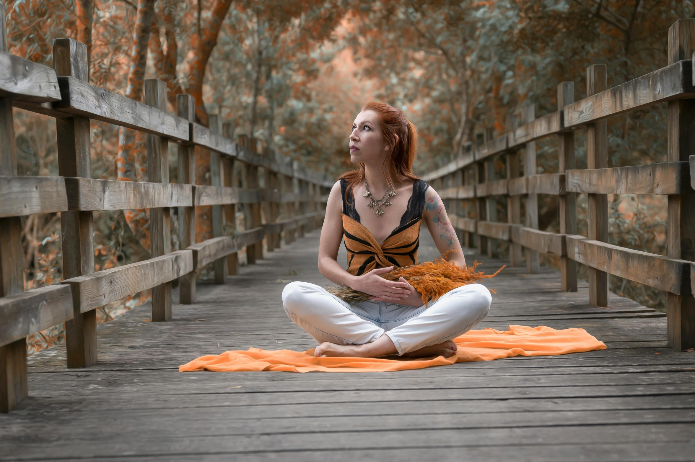 a woman sitting on a floor on top of a bridge